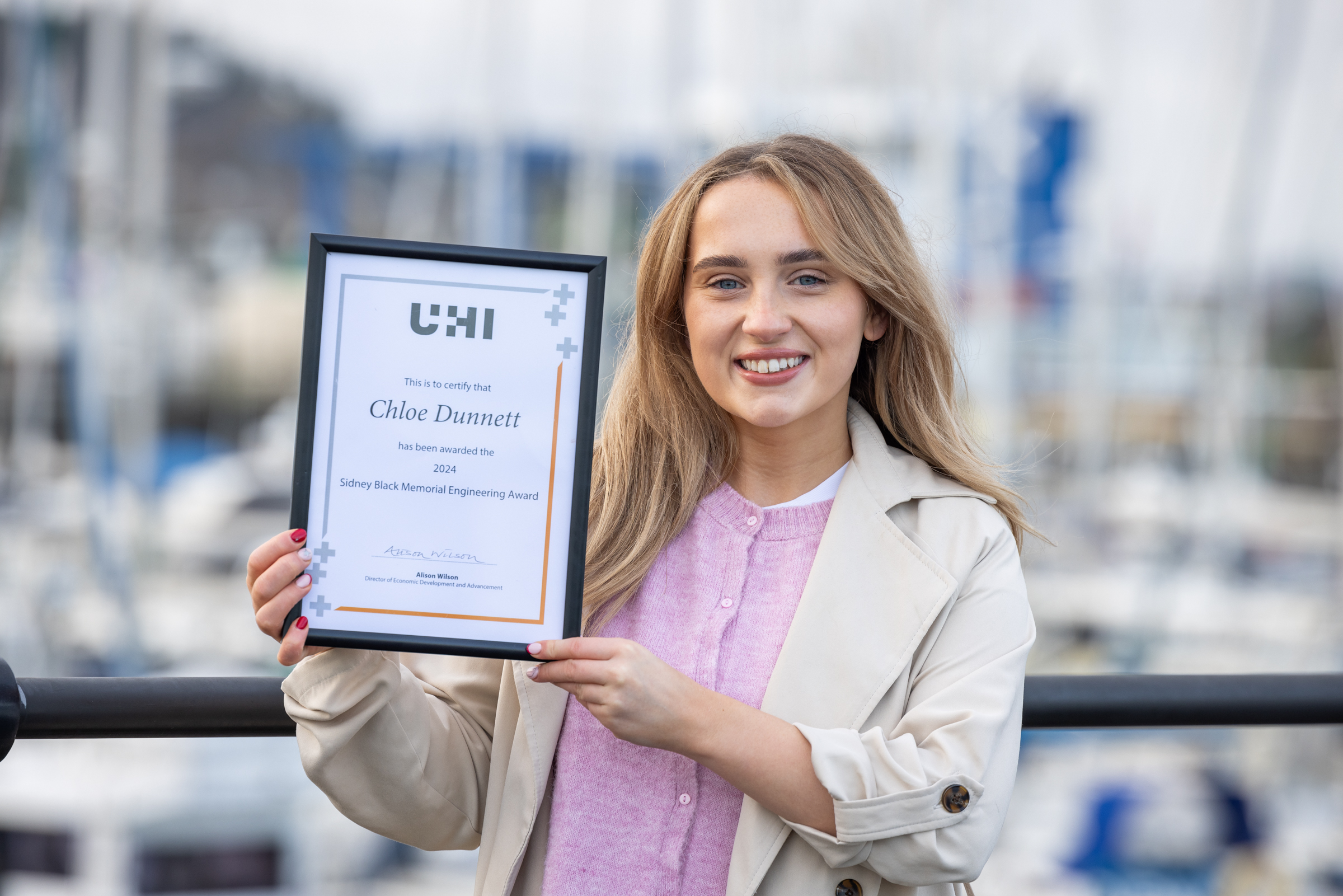 Graduate Chloe Dunnett holding a certificate from UHI Graduate Chloe Dunnett holding a certificate from UHI