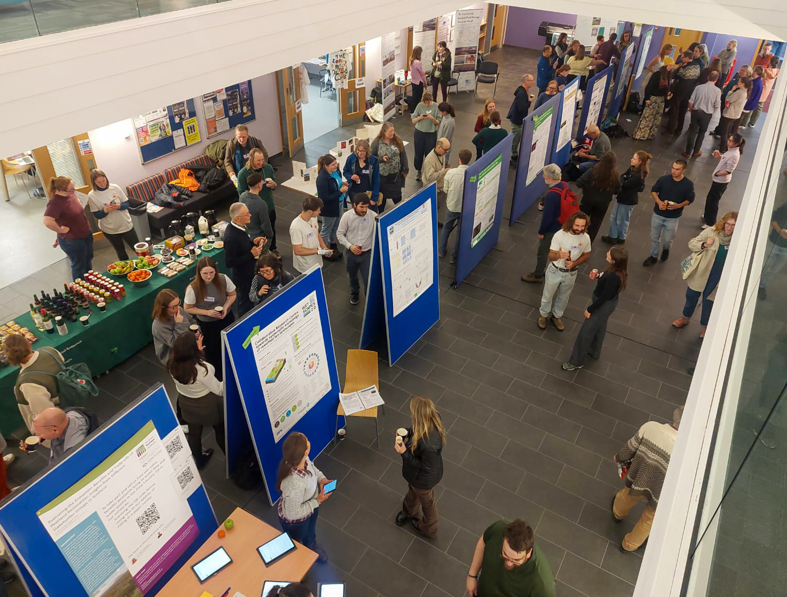Attendees viewing the poster session held at the Thurso campus. Artwork is inspired by the peatlands.