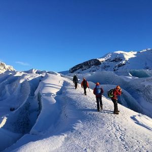 people climbing snow covered mountain