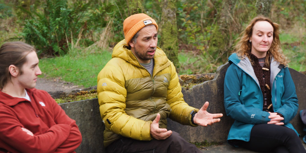 Two students and a practitioner in the outdoors having a discussion around therapeutic practice