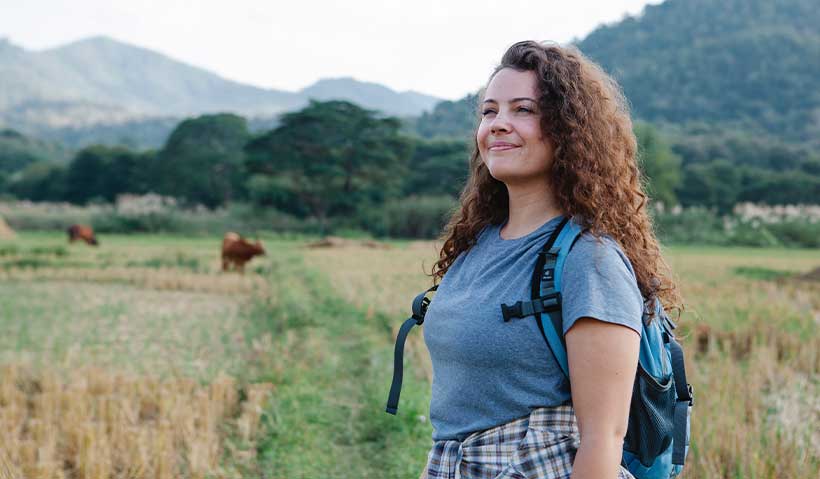 An adventurer walking through fields and trees