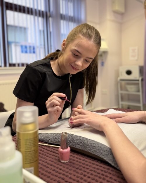 Senior phase student Carly Harrold practising nail treatment in the Thurso campus beauty salon