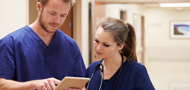 Two nurses looking at a clipboard
